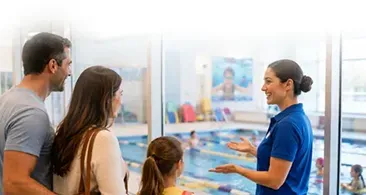 Employee speaking to family at a bright clinic reception desk