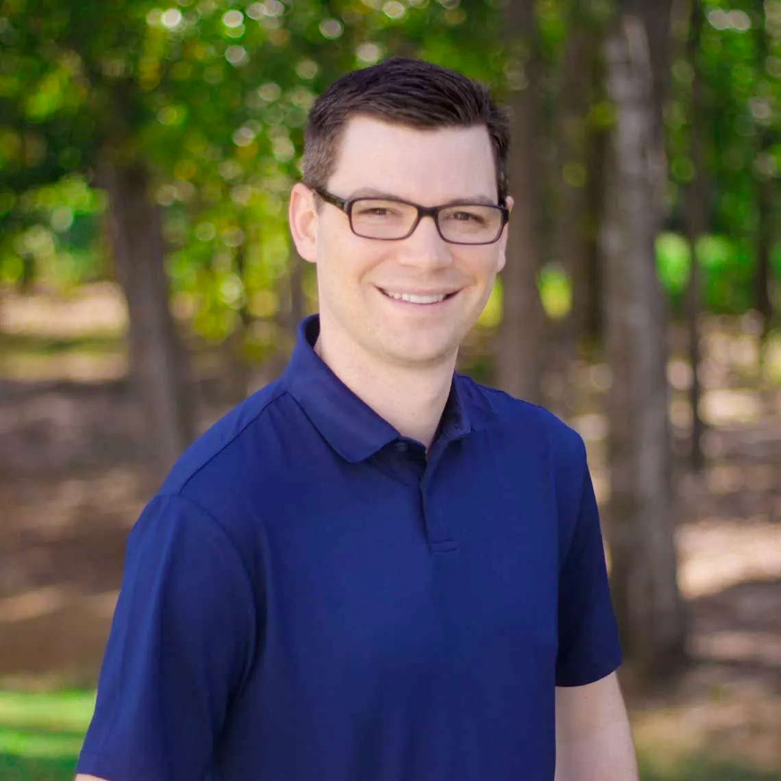 A smiling person with glasses