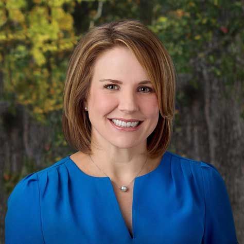 A woman with shoulder-length brown hair smiles