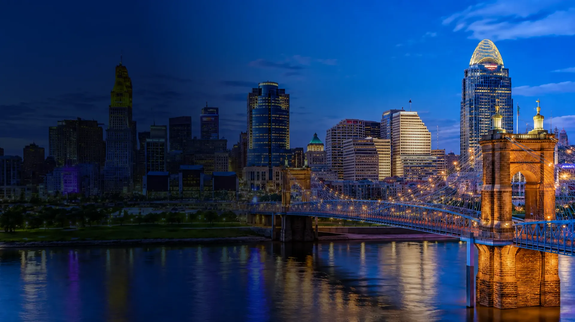 Night skyline of a city with illuminated skyscrapers reflected in calm water