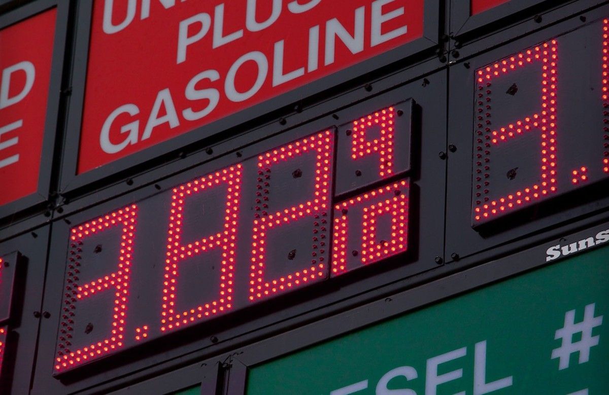 Gas station price sign with red digital numbers and “plus gasoline” text
