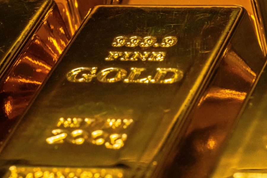 Close-up of gold bullion bars stacked in a warm, reflective display case