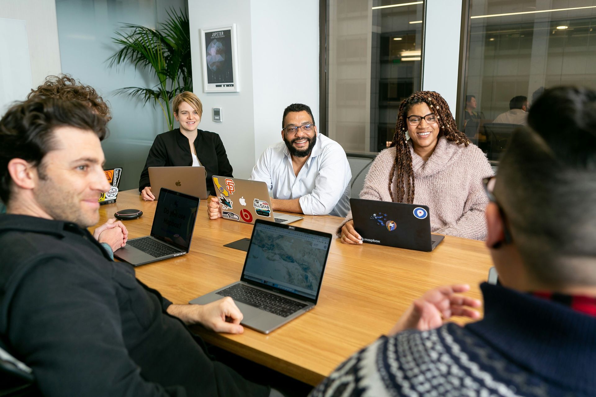 Entrepreneurs collaborating around a table with laptops 