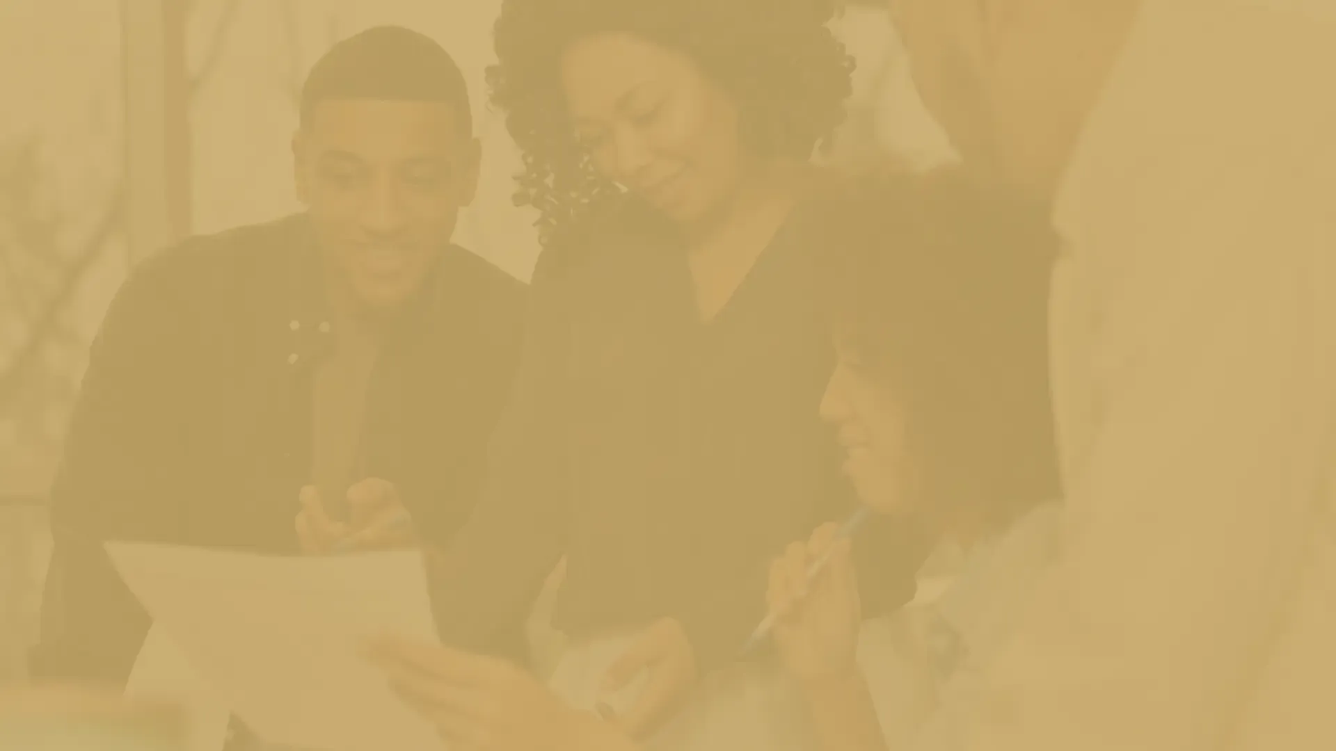 A group of people are sitting at a table using laptops.