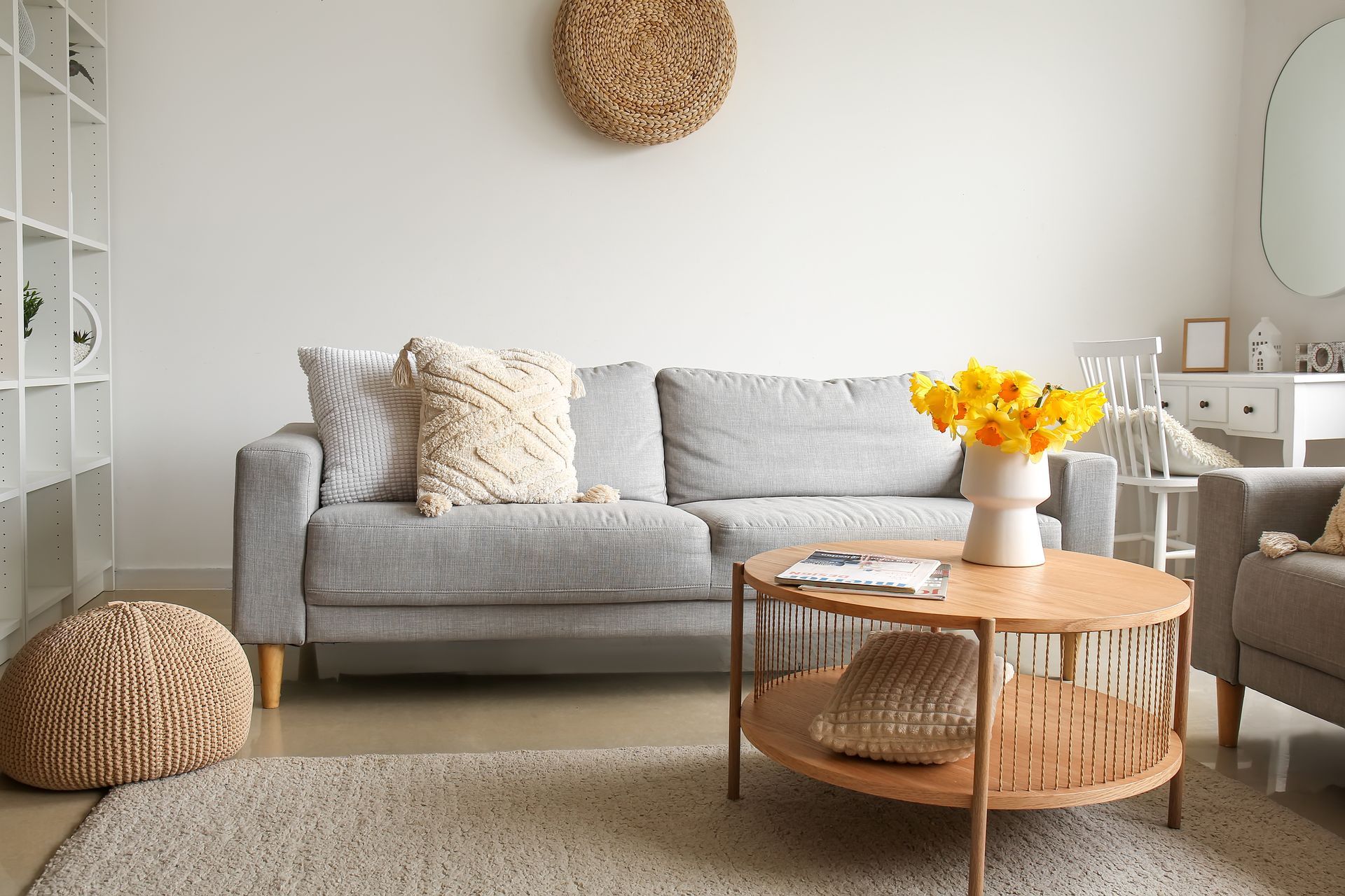 Living room with a gray sofa, round coffee table, and beige rug.