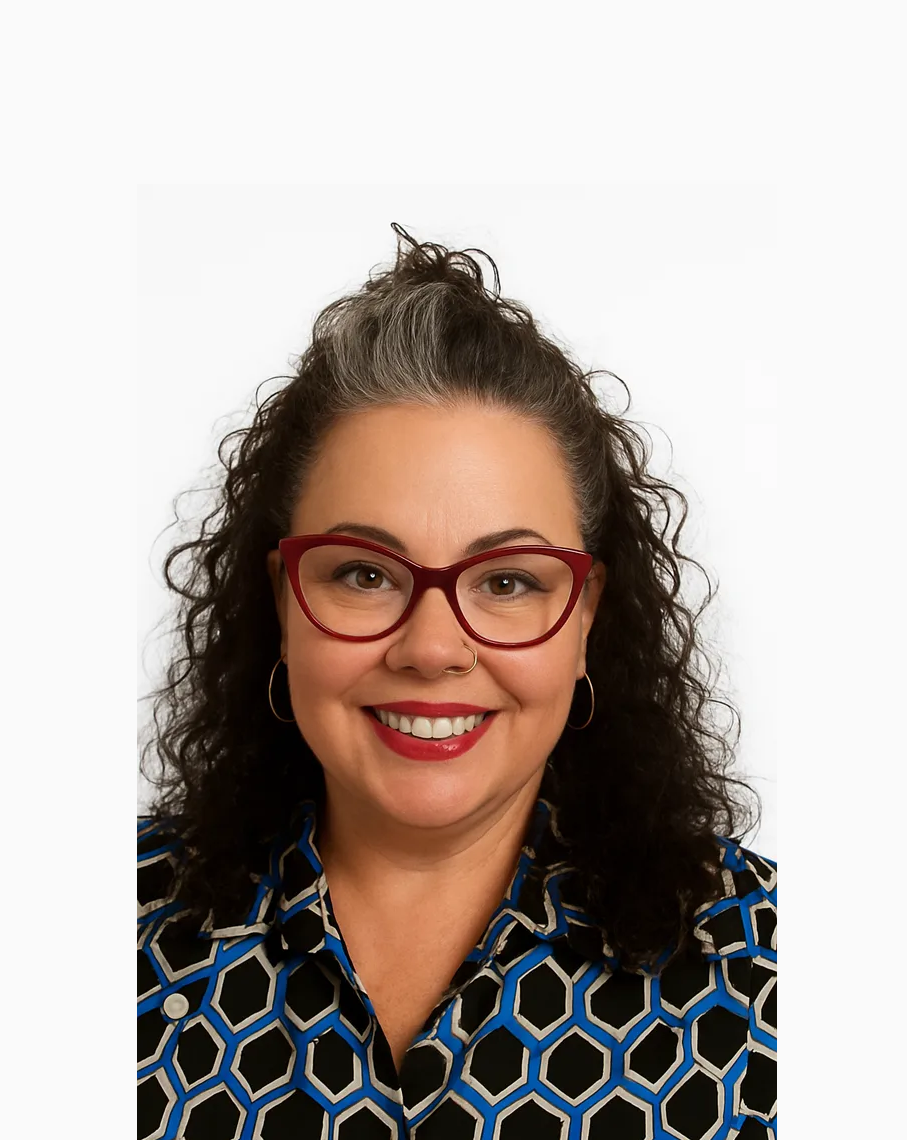 Woman with curly dark hair and glasses smiles.