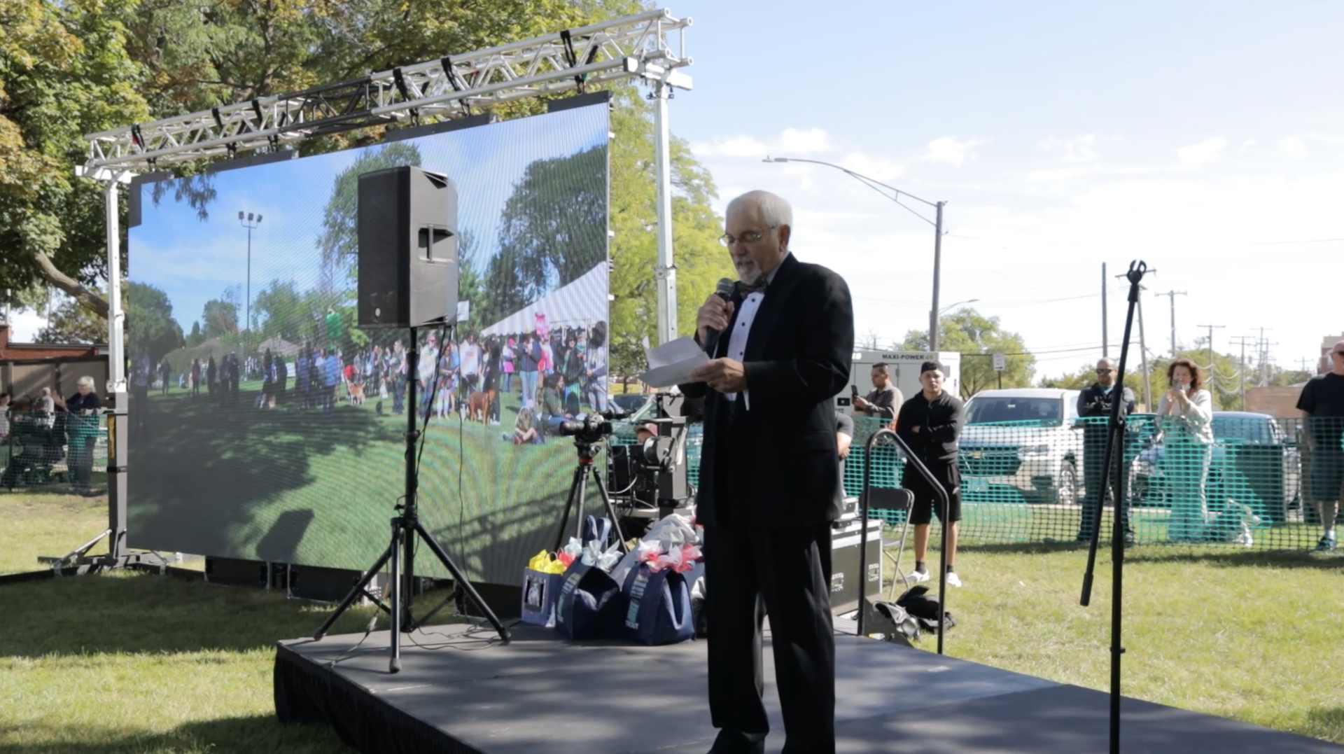 A man is standing on a stage talking into a microphone.