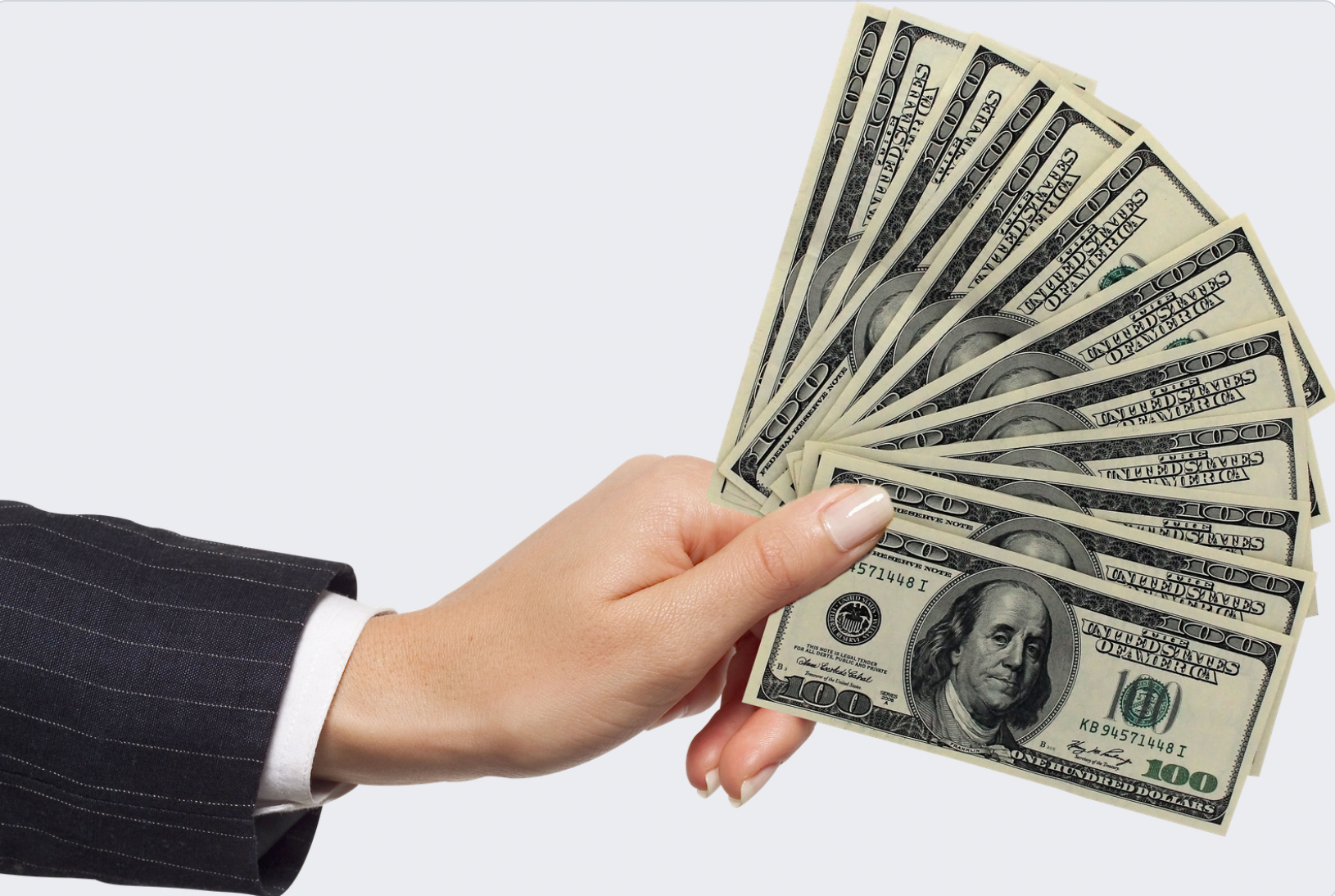 A person is holding a fan of 100 dollar bills
