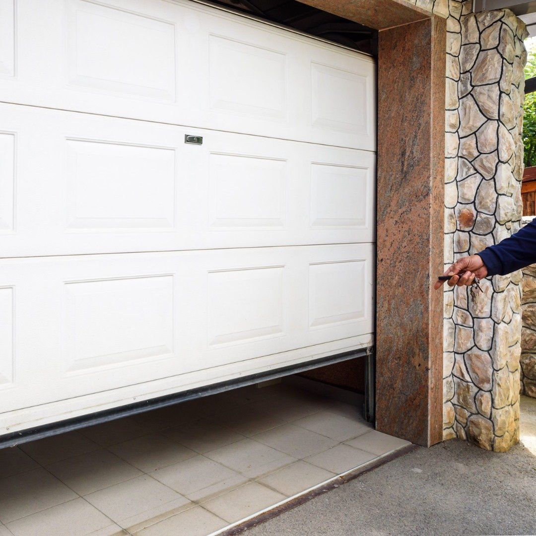 A man is opening a garage door with a remote control