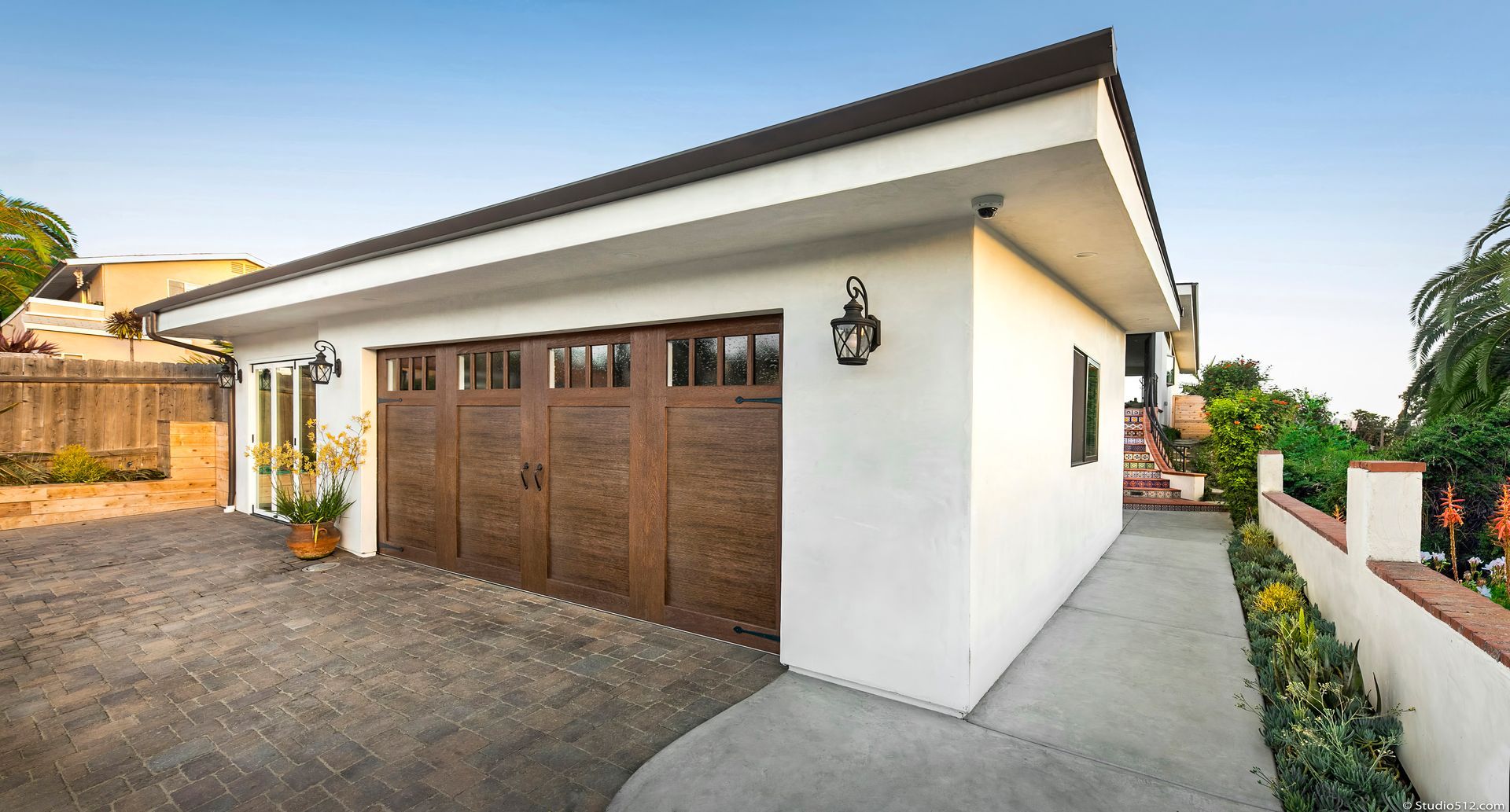 A large white house with two new wood finish garage doors