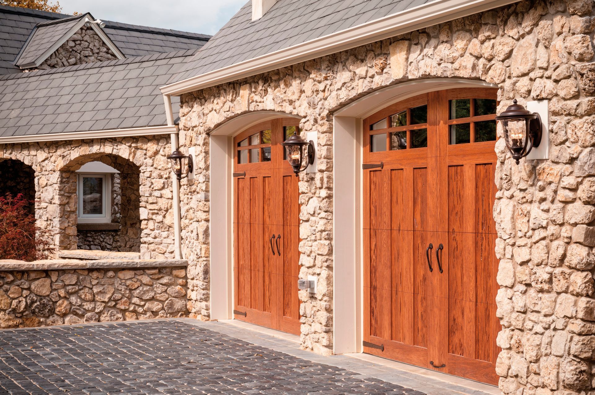 A house with a two car garage with wood and glass garage doors