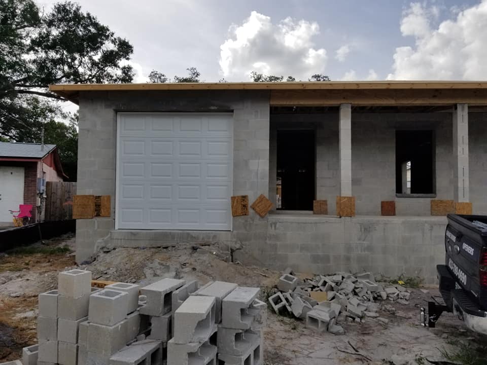 A white garage door in the middle of construction. 
