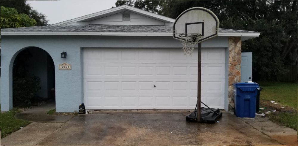 A white garage door with a basketball hoop in front of it