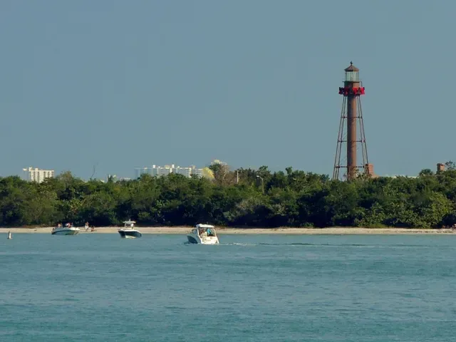 A lighthouse in the distance with boats in the foreground