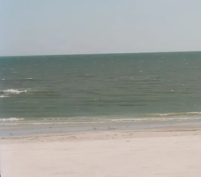 A beach with a large body of water in the background