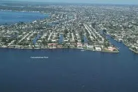 An aerial view of a city surrounded by water and houses.