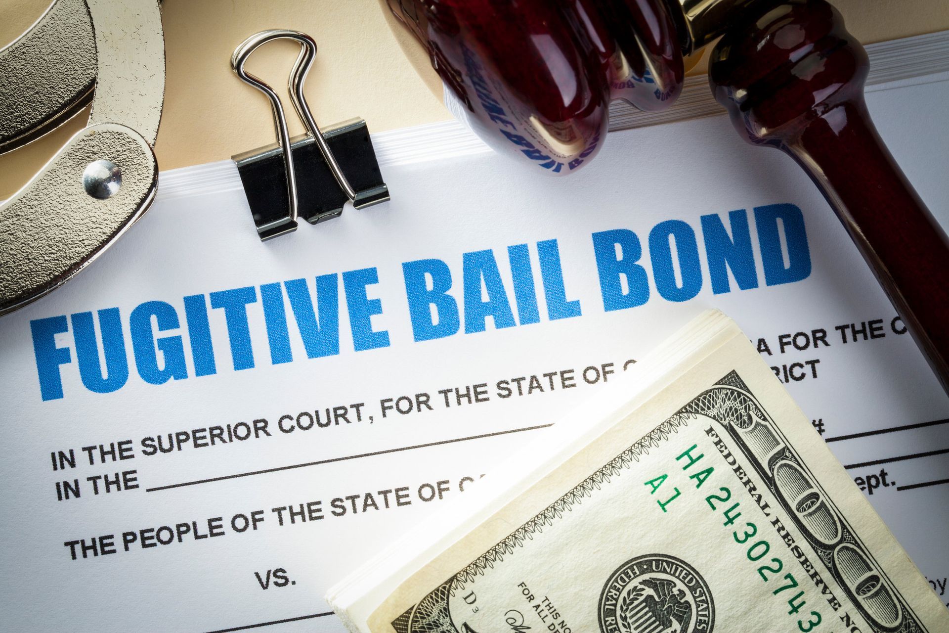 A fugitive bail bond with a dollar bill on top of it. A fugitive bail bond with a dollar bill on top of it.