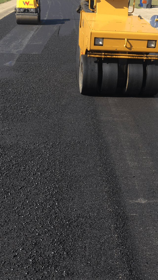 Yellow Truck Paving The Road — Houston, TX — HEV Asphalt Paving Co.