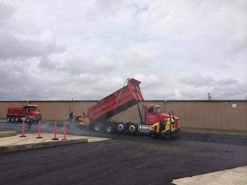 Red Truck Pouring Asphalt — Houston, TX — HEV Asphalt Paving Co.