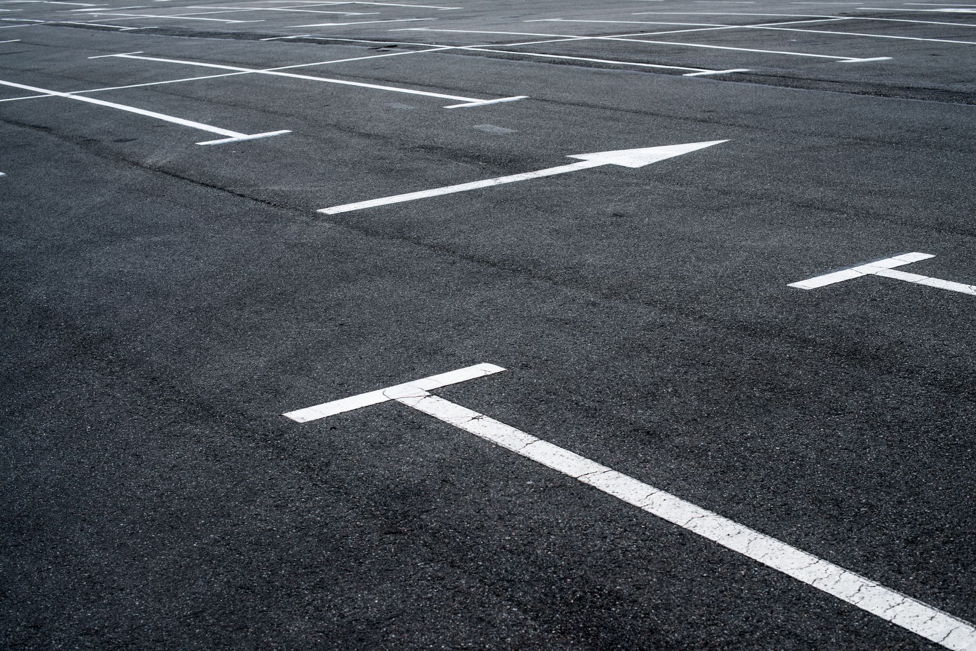 Newly paved parking lot with clean line markings highlighting expert parking lot paving services. Newly paved parking lot with clean line markings highlighting expert parking lot paving services.