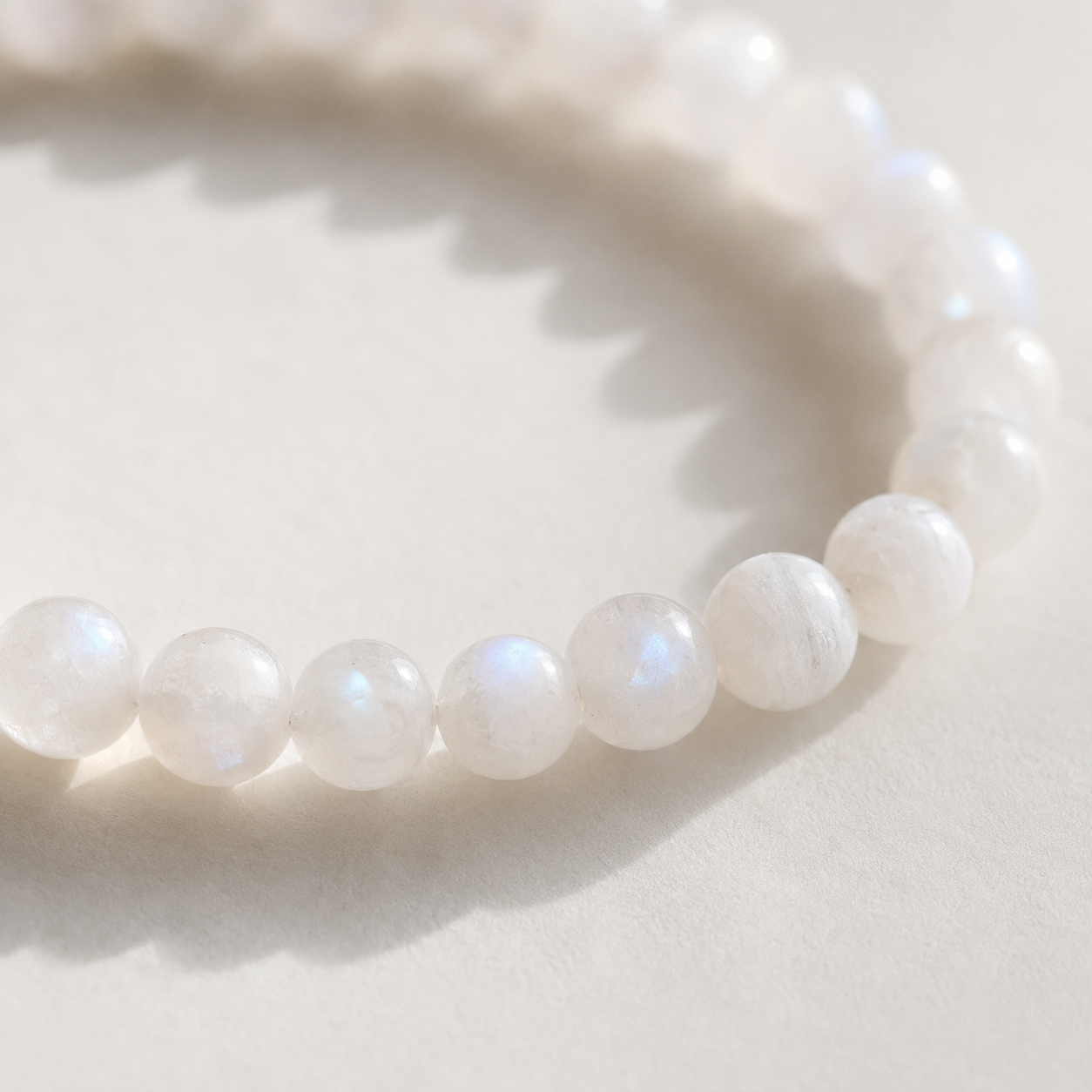 Elastische armband met melkwitte maansteenkralen van 6 mm