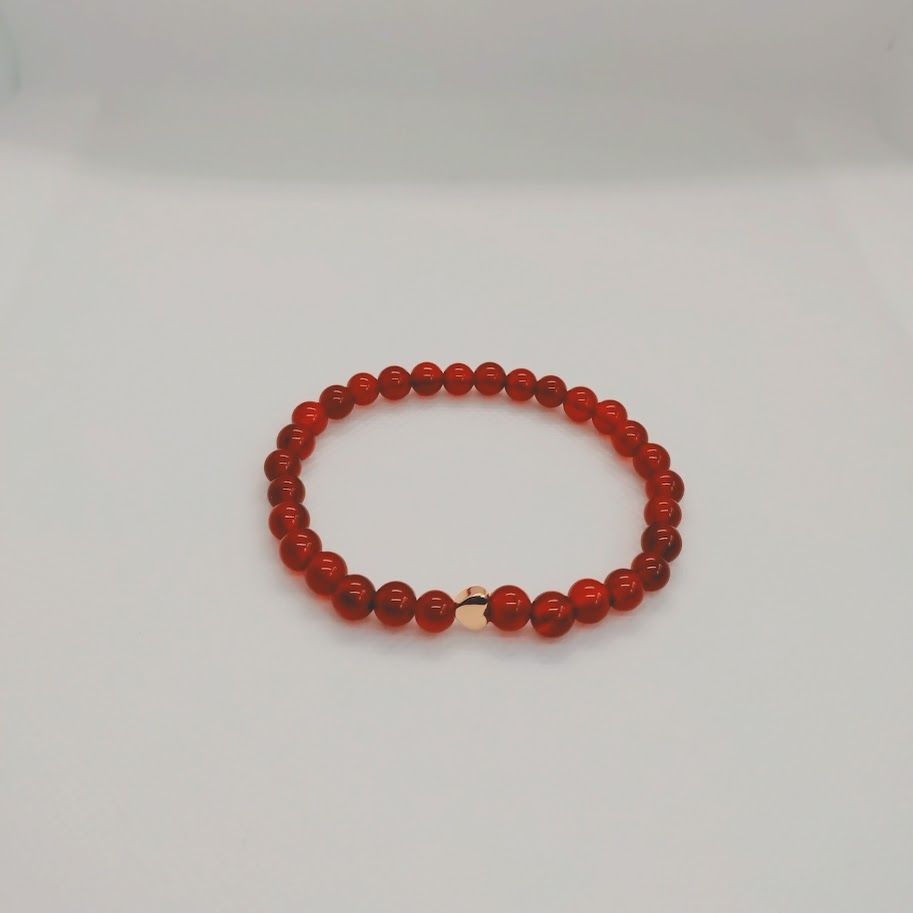 Armband van carneoolkralen geregen op elastiek.