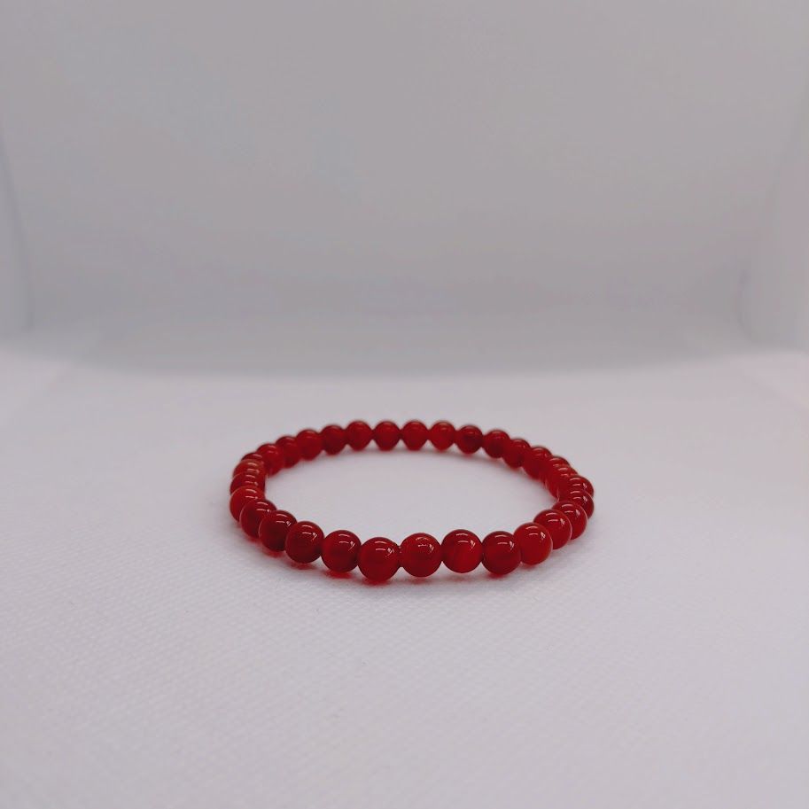 Armband van 6mm carneoolkralen geregend op elastiek.