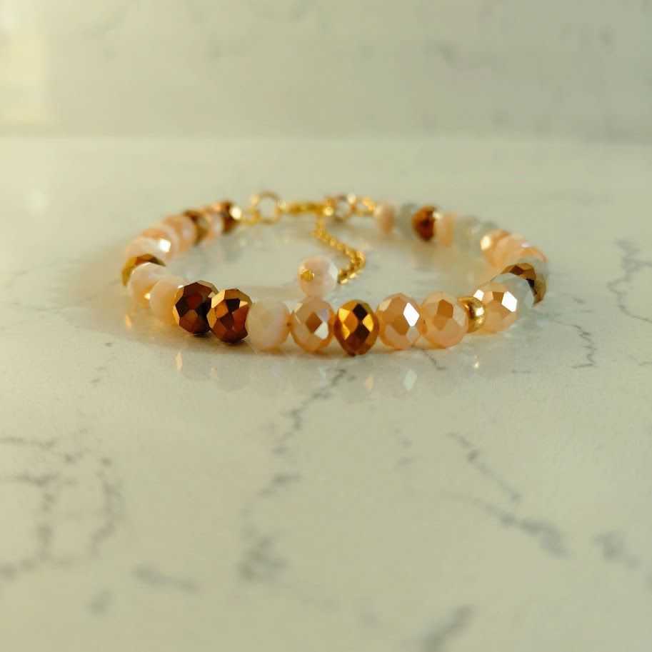 Luxe armband met goudkleur sluiting met verlengkettinkje van facetkralen in roze en bruine tinten.