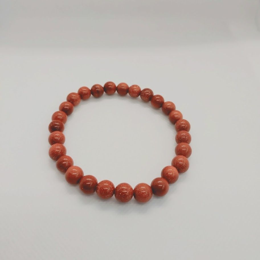 Armband van goudsteenkralen geregen op elastiek.