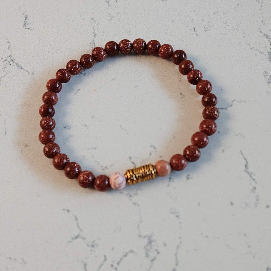 Armband van 6mm goudsteenkralen met een gouden stainless steel spiraal tussenkraal