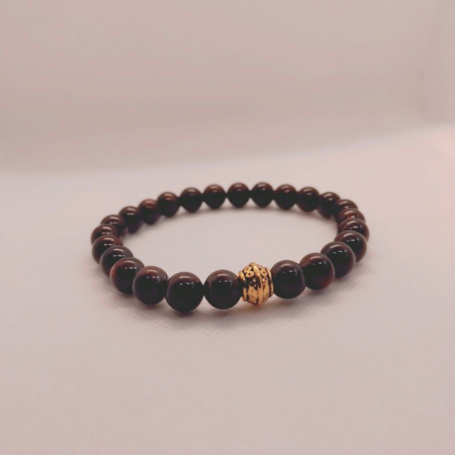 Armband van granaatkralen met goudkleur tussenkraal geregen op elastiek.