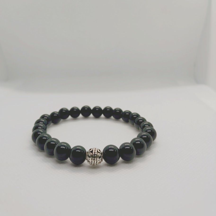 Armband van obsidiaankralen met zilverkleur tussenkraal geregen op elastiek.