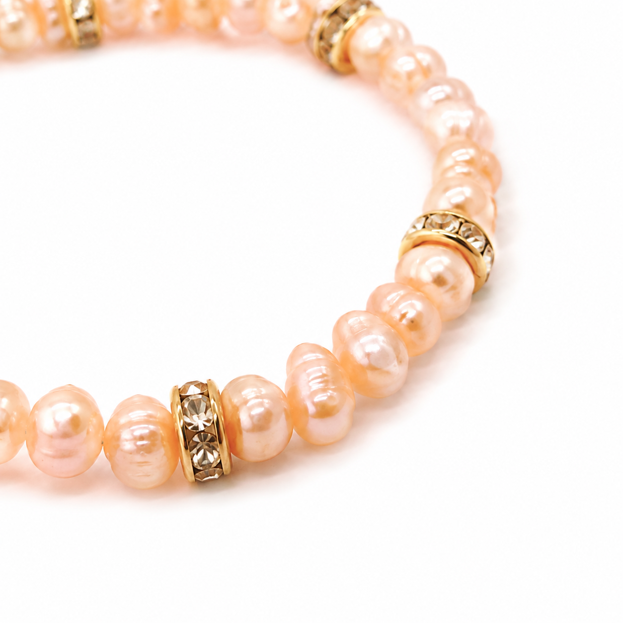 Roze zoetwaterparel armband met goudkleurige strass rondellen op witte achtergrond
