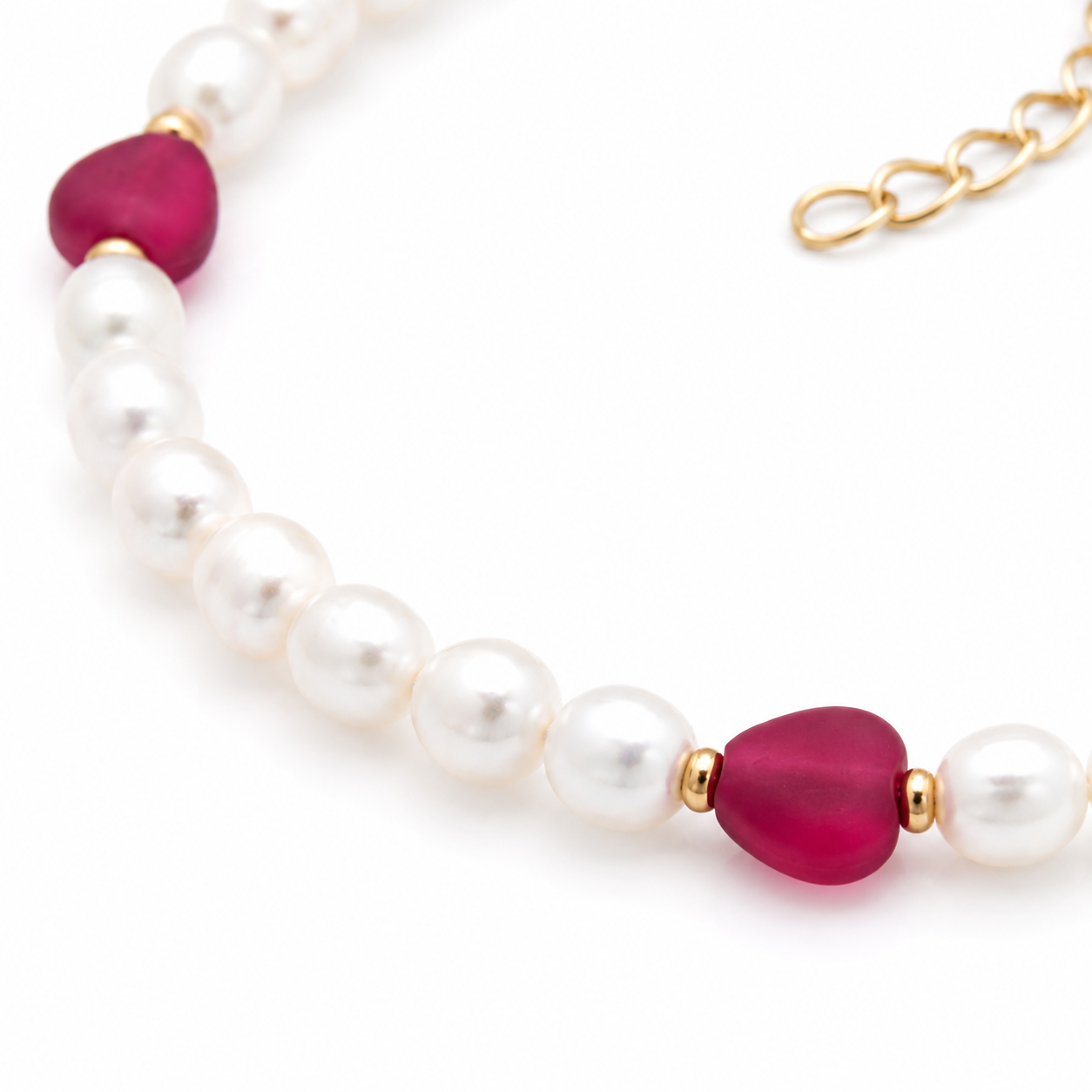Witte zoetwaterparel armband met rode hartjes en goldplated sluiting op witte achtergrond