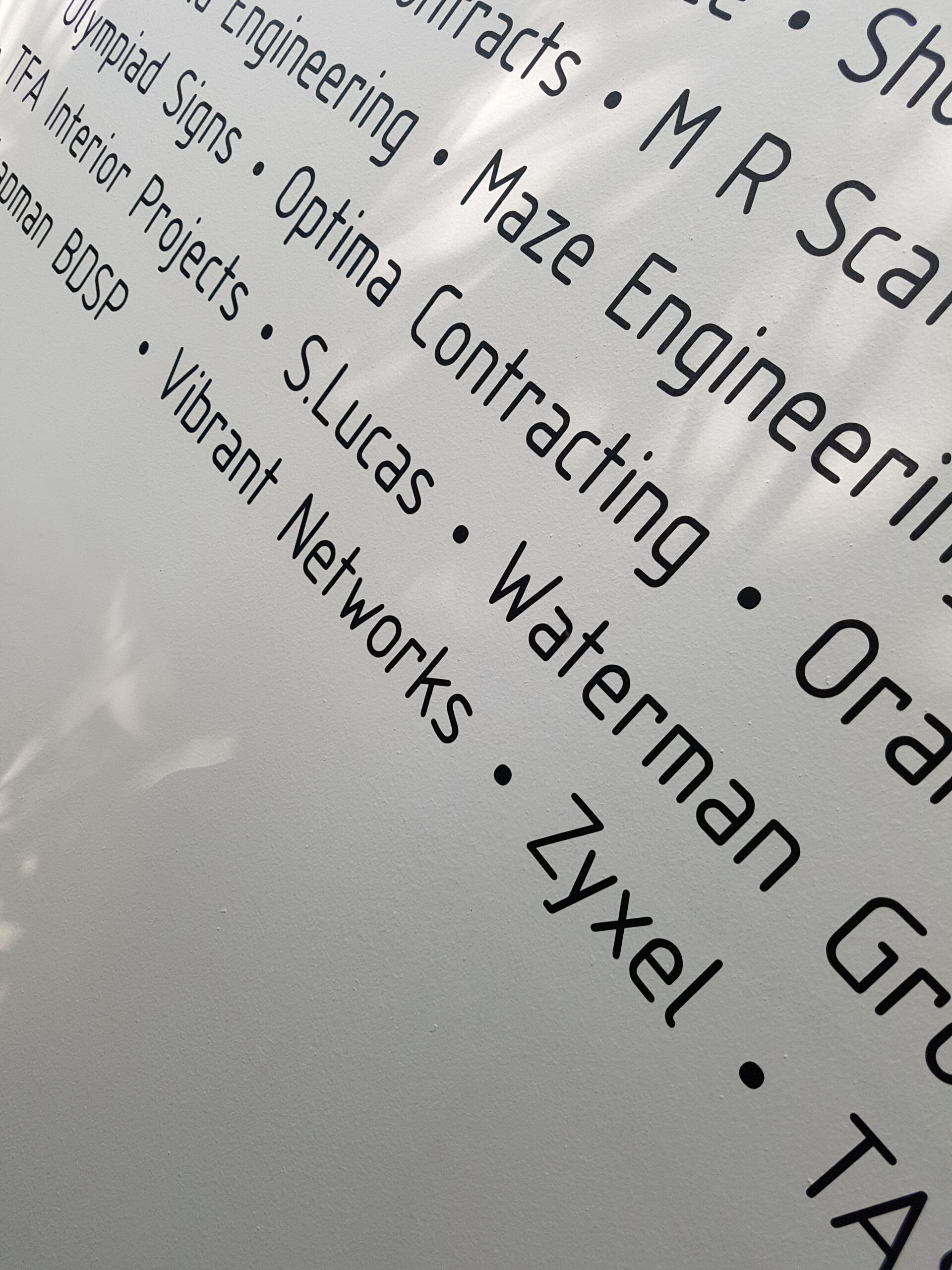 Close-up of a tilted printed list of company names in black text on white paper.
