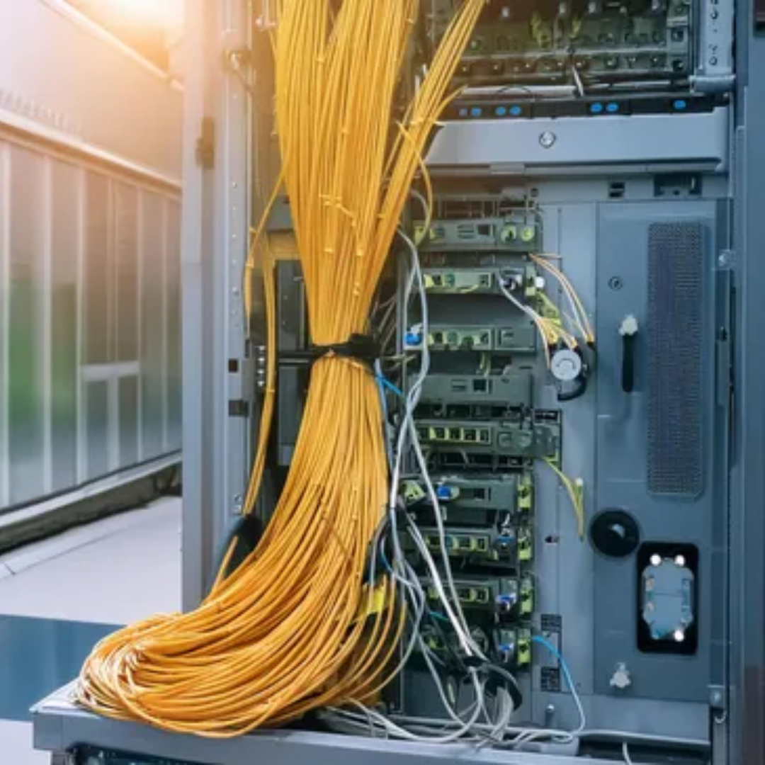 Yellow fiber-optic cables connected to a network server rack in a data center