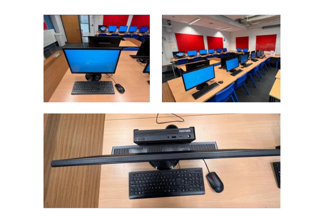 School computer lab with desktop monitors, keyboards, and mice on desks in a row under red window blinds