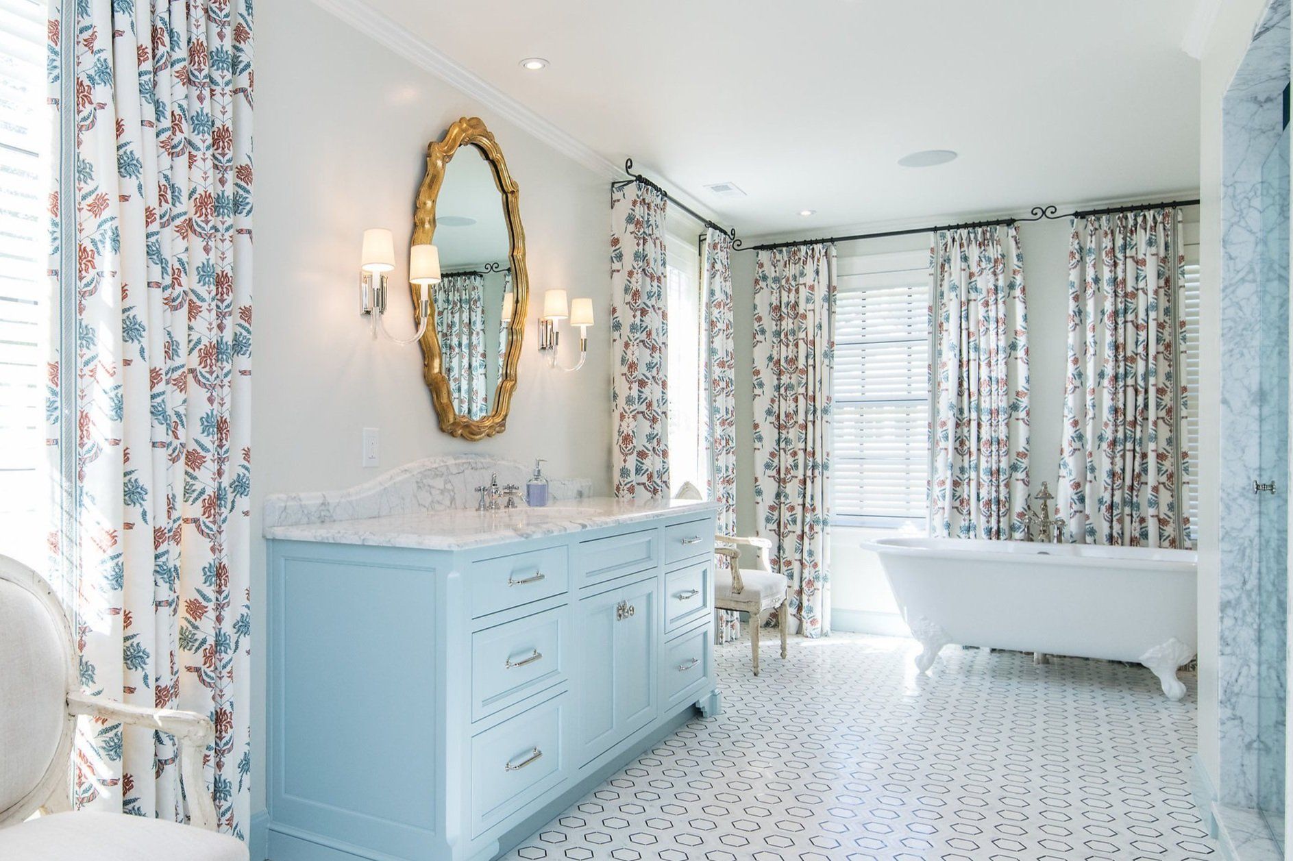 A bathroom with a tub , sink , mirror and curtains.