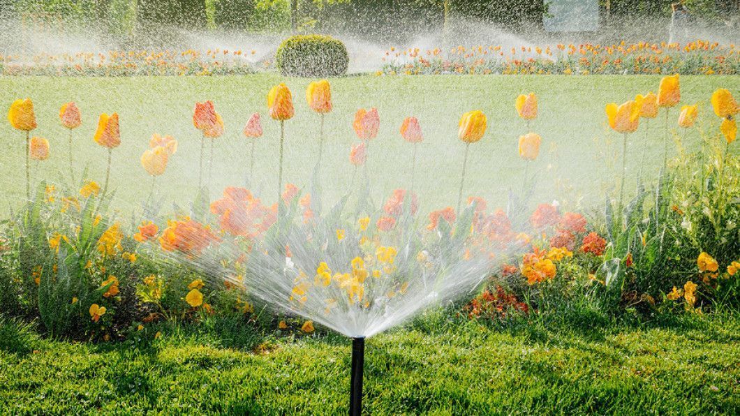 Irrigation system watering lawn and landscaped flower beds