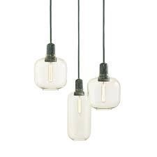 Three hanging pendant lights with frosted glass shades and dark cords on a white background