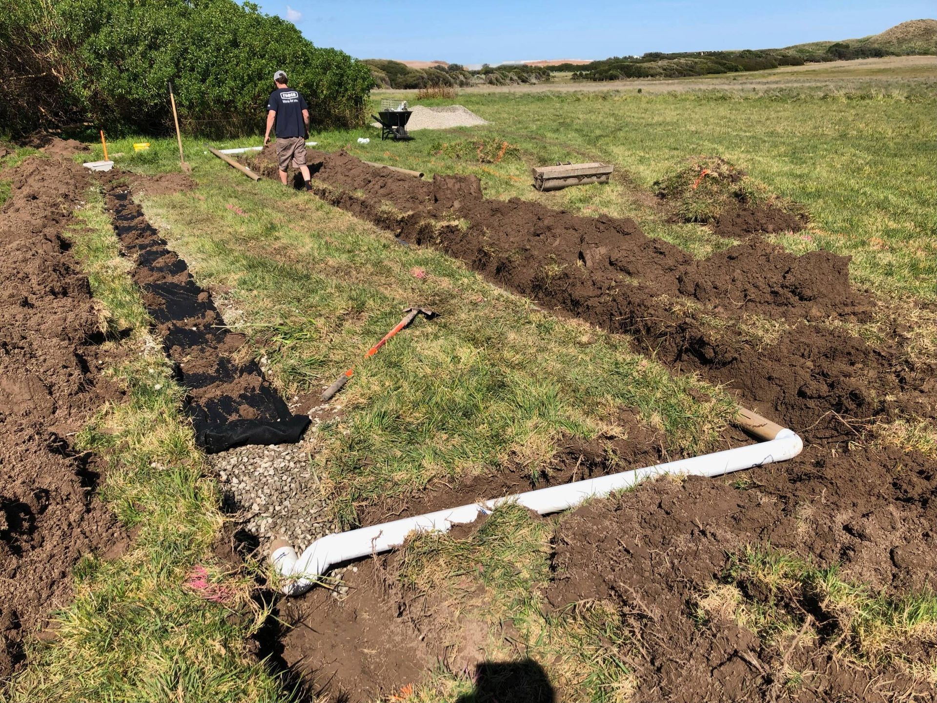 Person Working in A Garden Plot with  White Irrigation Piping — NoDrip Plumbing & Roofing In Port Macquarie, NSW