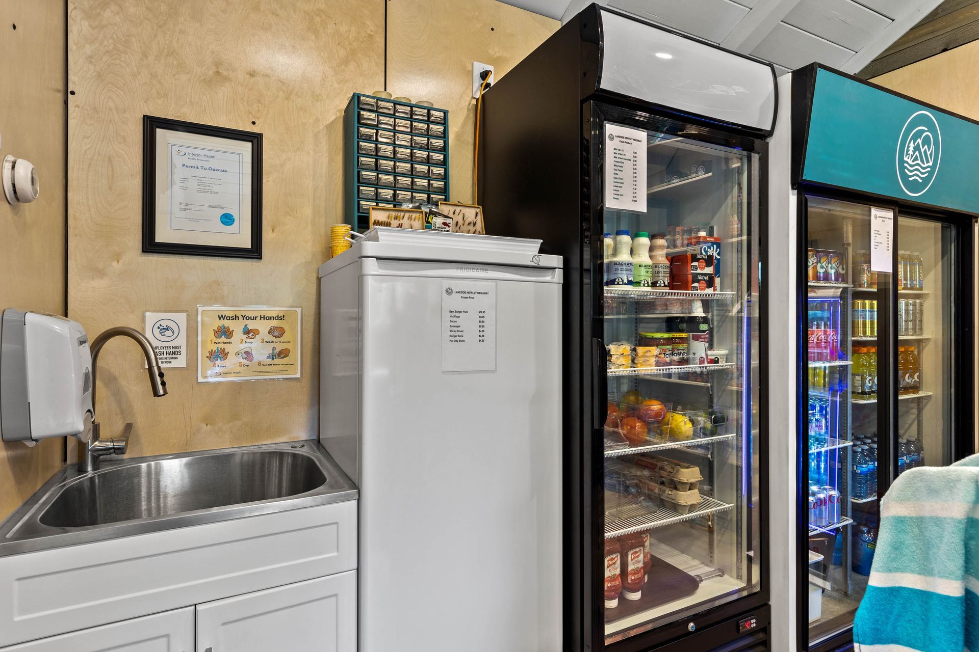 A kitchen with a sink , refrigerators , and a freezer.