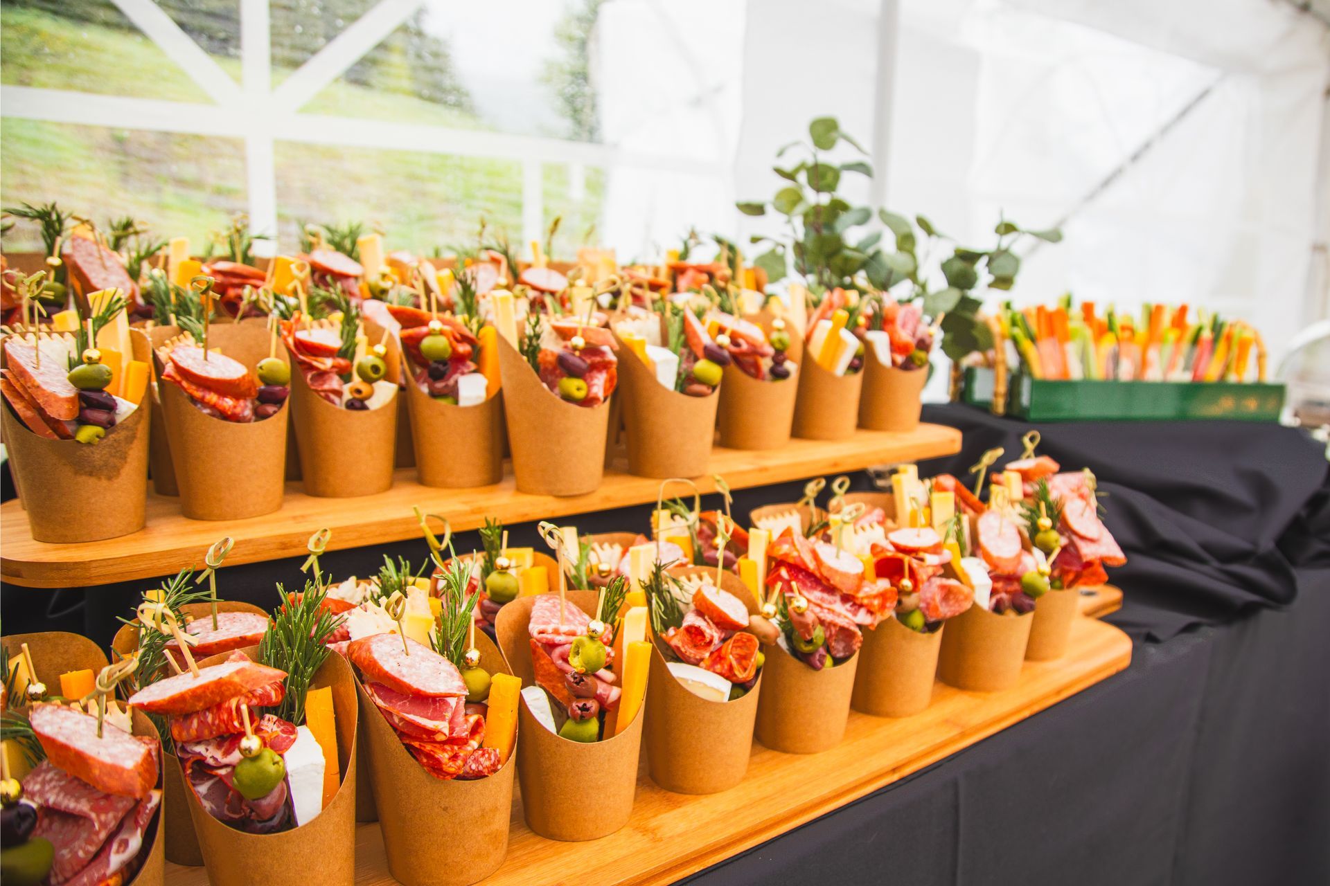 A table topped with a variety of food in paper cups.