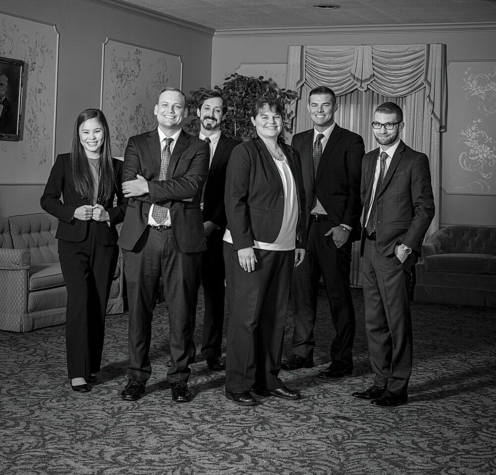 A group of people in suits and ties are posing for a picture in a living room.