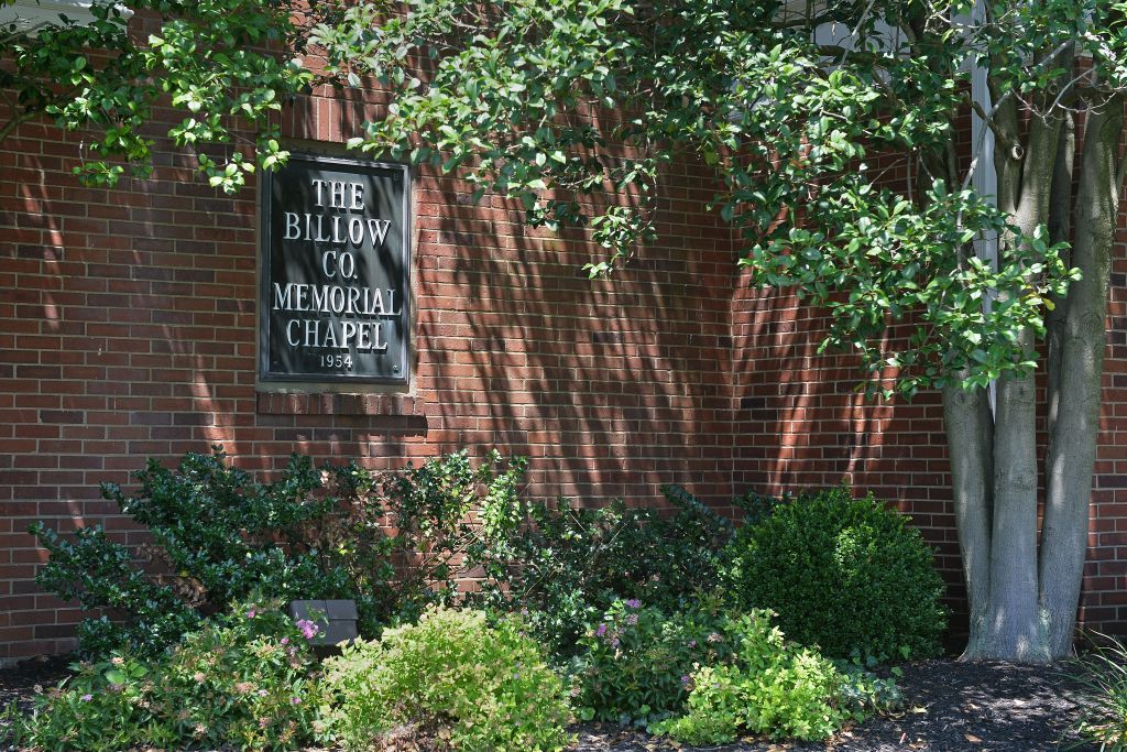 A brick wall with a sign that says the ballard co memorial chapel