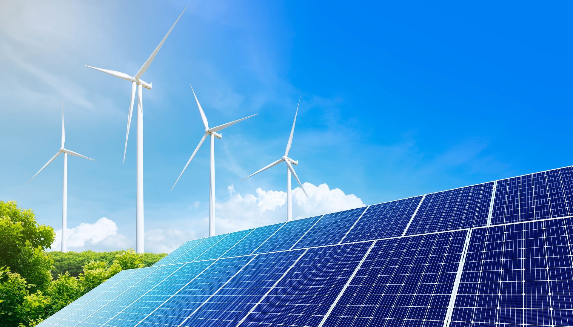 Solar panels in a field with wind turbines under a bright blue sky.