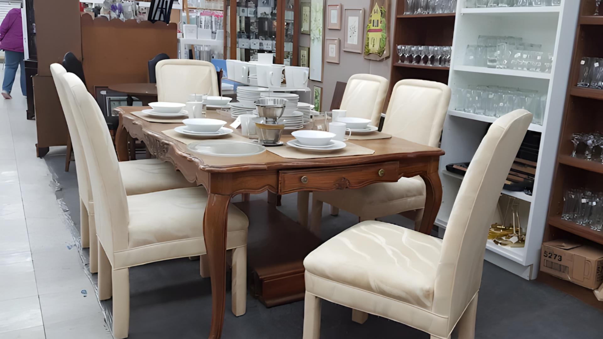 Antique shop interior filled with furniture, mirrors, shelves of items, and a wooden trunk.