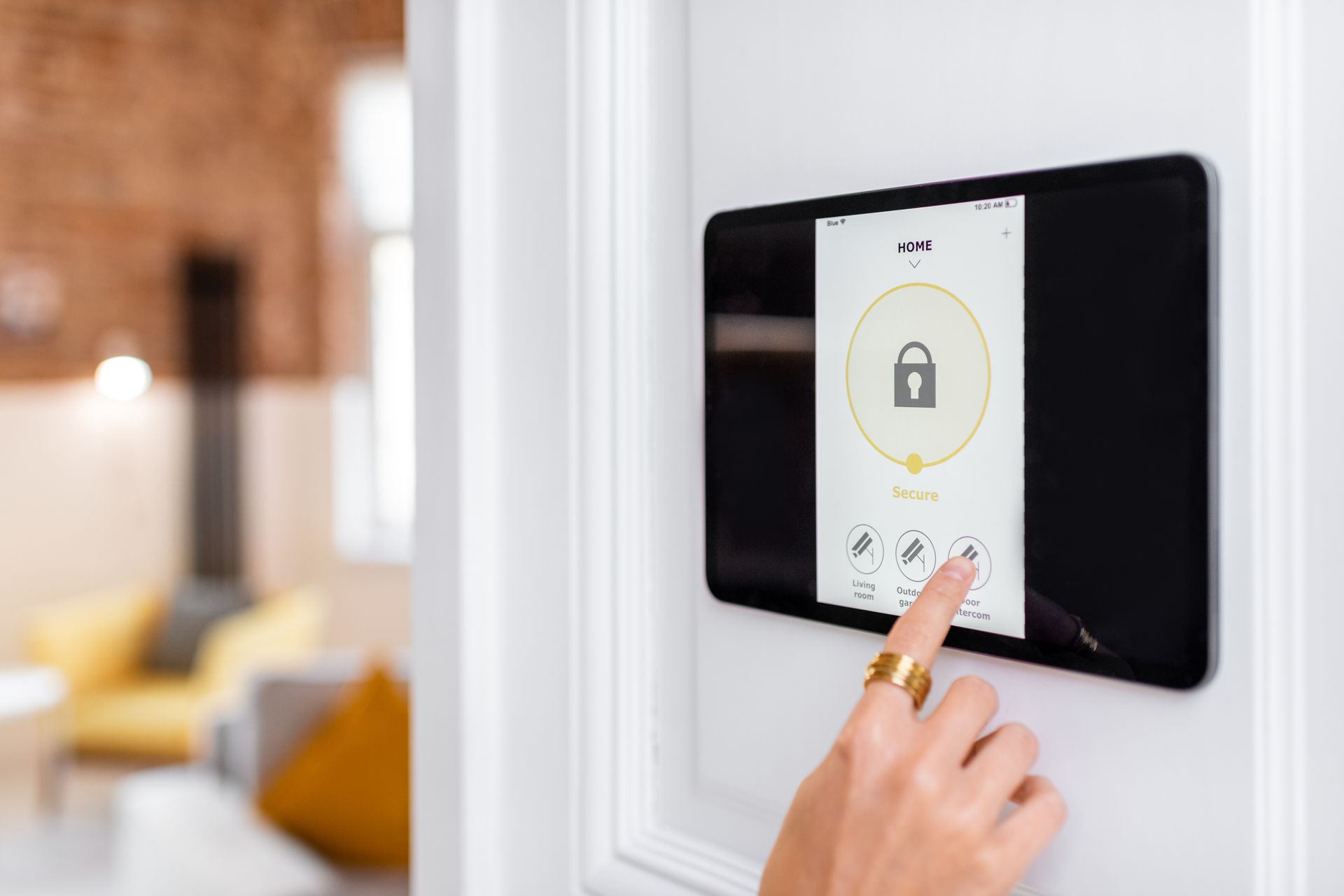 A person's hand controls the alarm system with a digital touch screen panel installed on the wall. A person's hand controls the alarm system with a digital touch screen panel installed on the wall.