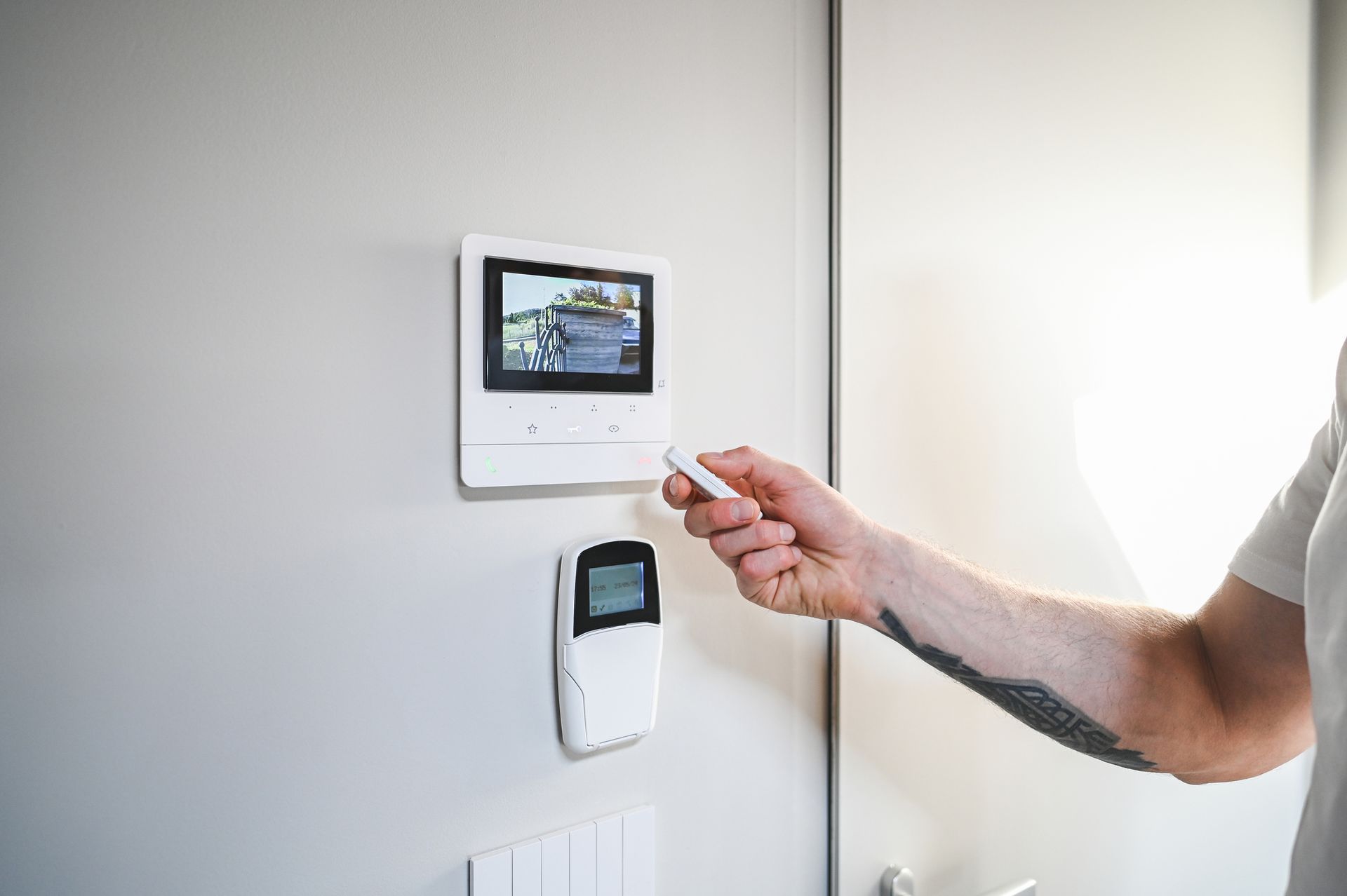 A man pointing to a wall camera, representing alarm systems for effective surveillance solutions. A man pointing to a wall camera, representing alarm systems for effective surveillance solutions.