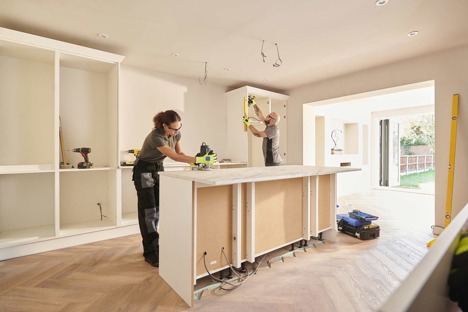A man and a woman are working on a kitchen island